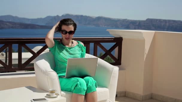 Vrouw die op laptop werkt op terras — Stockvideo