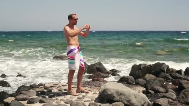 Człowiek biorąc Zdjęcie przez morze — Wideo stockowe