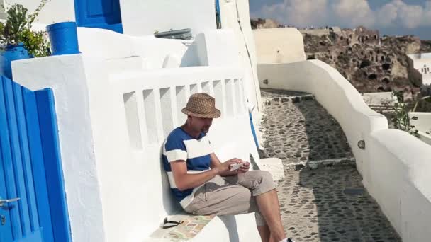Турист фотографируется с сотовым на Санторини — стоковое видео