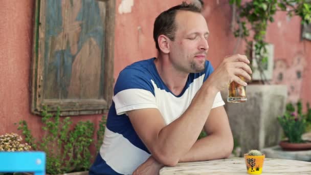 Человек, пьющий пиво в кафе — стоковое видео