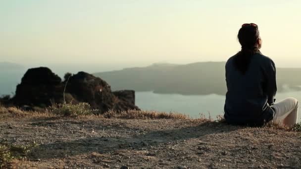 Ensam kvinna sitter på klippa — Stockvideo