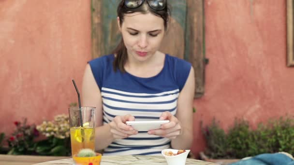 Hermosa mujer con teléfono inteligente en la cafetería — Vídeo de stock