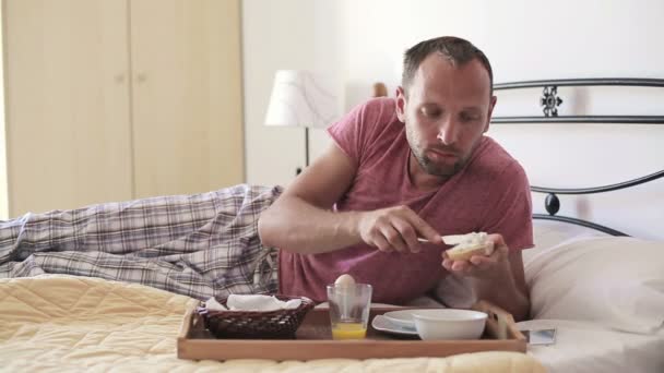 Man eating breakfast in bed — Stock Video