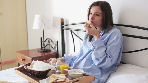 Femme au lit manger le petit déjeuner — Video