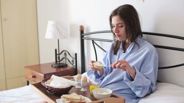 Woman in bed eating breakfast — Stock Video