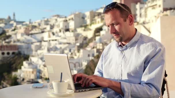 Человек с ноутбуком пьет кофе — стоковое видео
