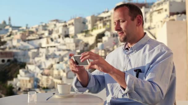 Hombre tomando fotos con el teléfono celular en la cafetería — Vídeos de Stock