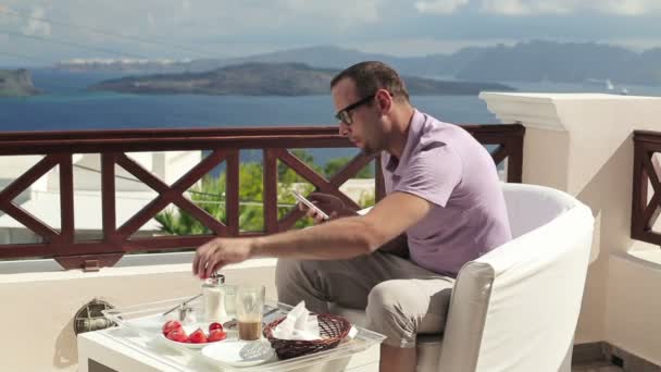 Hombre usando smartphone durante el desayuno — Vídeo de stock