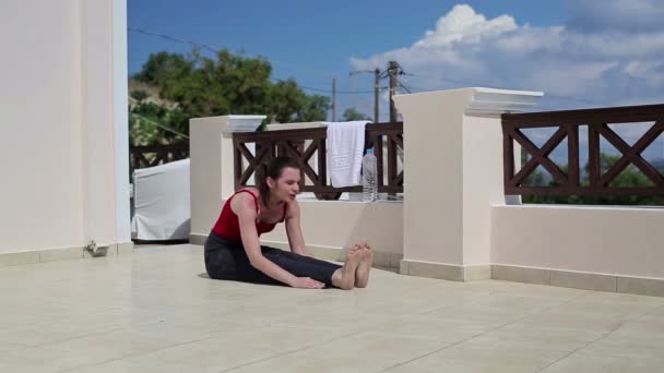 Женщина растягивается на террасе — стоковое видео