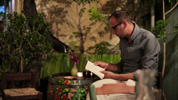 Muž čtení knihy a pití vína — Stock video