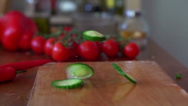 Cucumber falling on chopping board — Stock Video