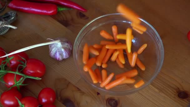 Carrots falling in bowl — Stock Video
