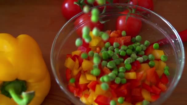 Guisantes cayendo en tazón con ensalada — Vídeo de stock