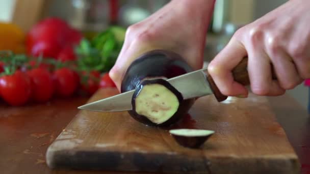 Kvinna skivas aubergine på skärbräda — Stockvideo