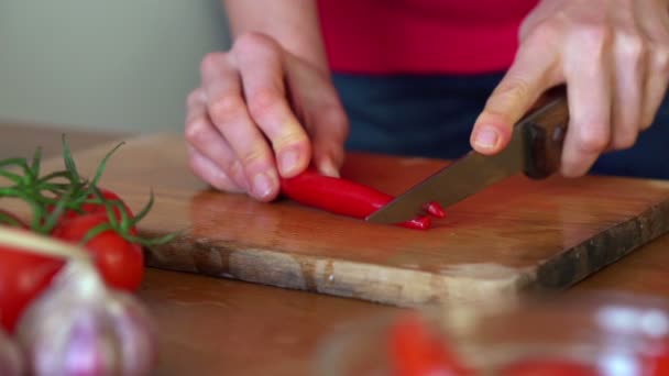 Slicing hot pepper on chopping board — Stock Video