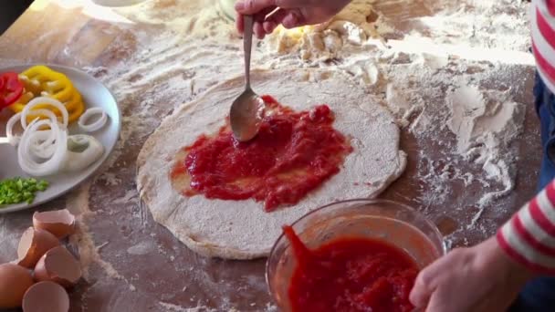 Spreading tomato sauce on pizza — Stock Video