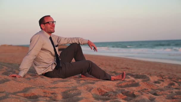 Бизнесмен отдыхает на пляже — стоковое видео