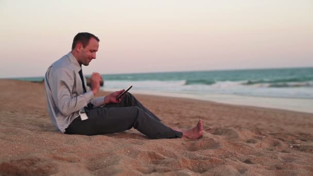 Businessman with tablet computer on beach — Stock Video