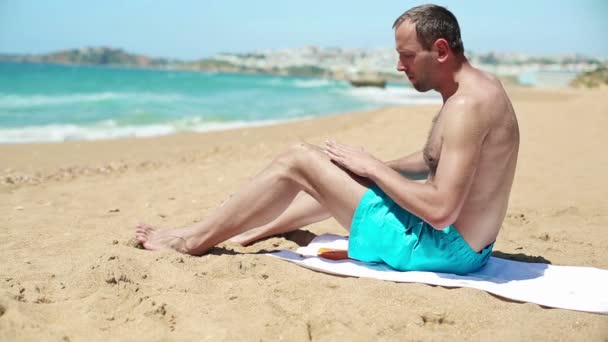 Man tillämpa solskyddsmedel lotion på ben — Stockvideo