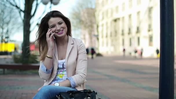 Vrouw praten over cellphone in stad — Stockvideo