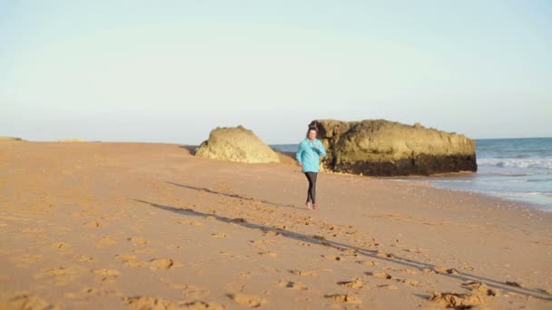 Man and woman jogging on beach — Stock Video