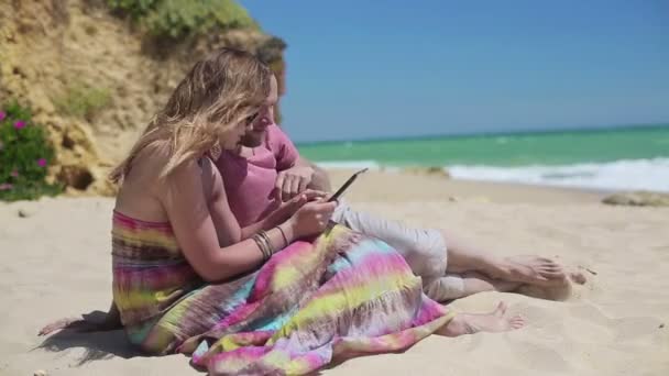 Ζευγάρι με δισκίο στην παραλία — Αρχείο Βίντεο