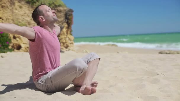 Man mediterar på stranden — Stockvideo