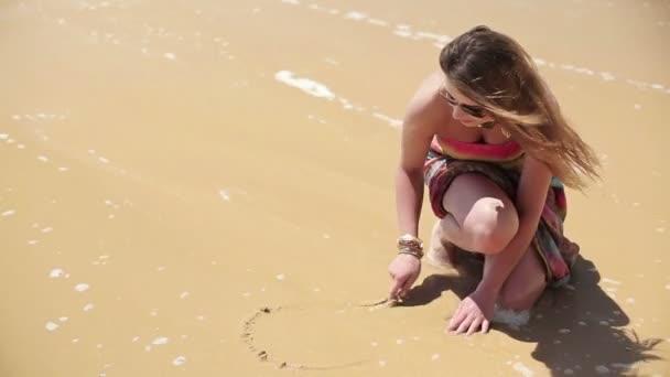 Mujer dibujando corazón en arena — Vídeo de stock
