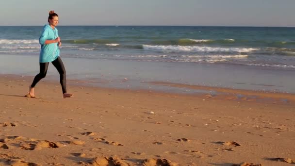 Kvinnan joggar på stranden — Stockvideo