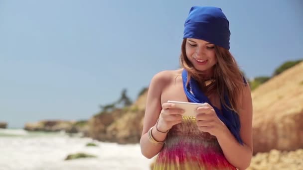 Frau benutzt Smartphone am Strand — Stockvideo