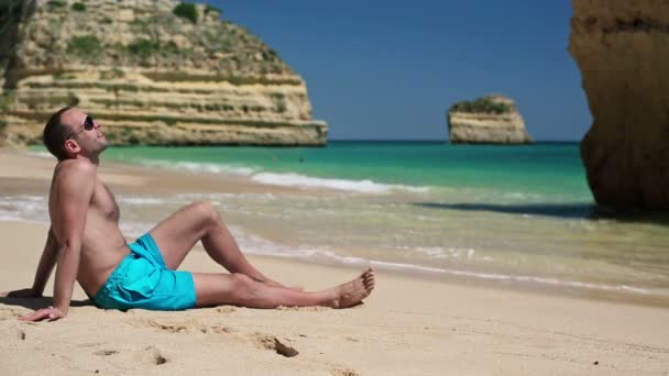 Uomo rilassante sulla bellissima spiaggia — Video Stock