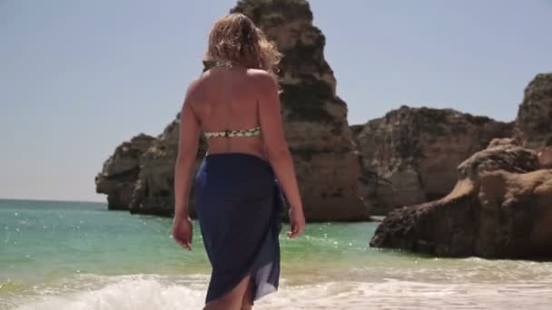 Vrouw die op het strand loopt — Stockvideo