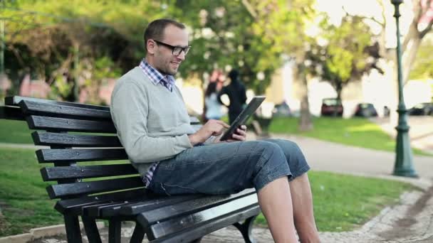 Człowiek z komputera typu tablet w parku — Wideo stockowe