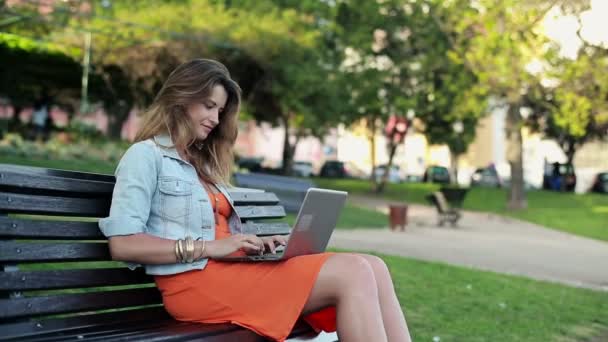 Vrouw met laptop in het stadspark — Stockvideo