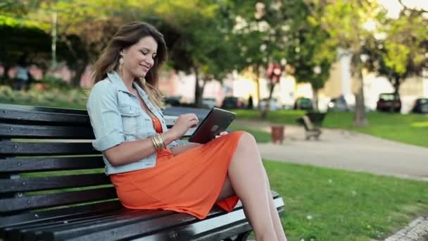 Mulher bonita com computador tablet no parque — Vídeo de Stock