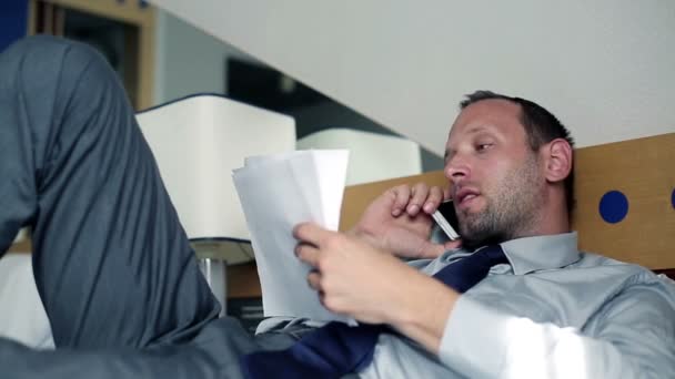 Бизнесмен разговаривает по мобильному телефону в отеле — стоковое видео