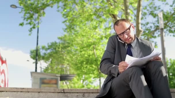 Businessman with cellphone and documents — Stock Video