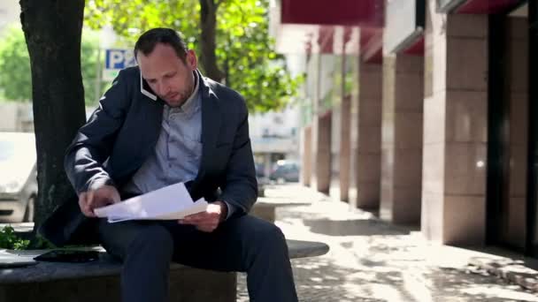 Homme d'affaires avec téléphone portable et documents — Video