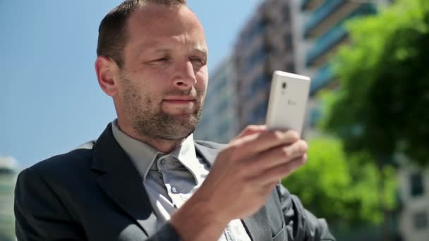 Businessman with smartphone in the city — Stock Video