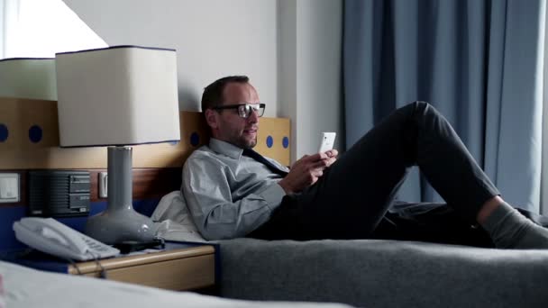 Affärsman med smartphone i hotellrum — Stockvideo