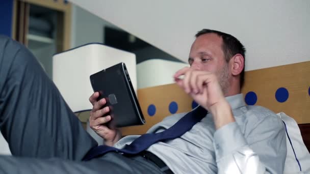 Businessman with tablet computer in hotel room — Stock Video