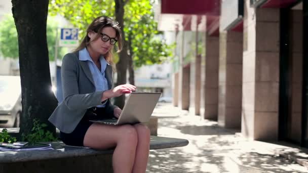 Zakenvrouw met laptop in stad — Stockvideo