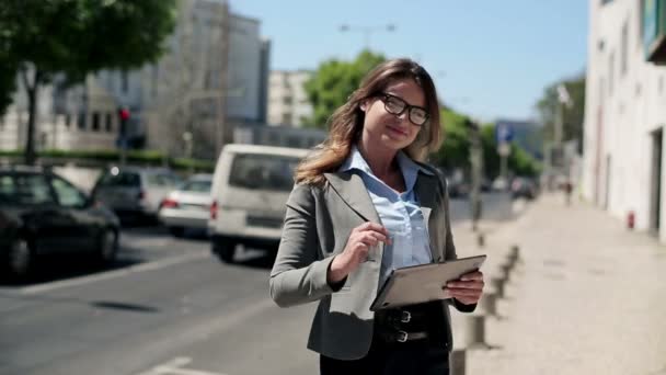 Businesswoman with tablet computer by street — Stock Video