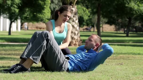 Homem fazendo crunches com a ajuda do treinador — Vídeo de Stock