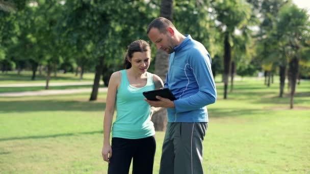 Trainer spiega esercizio con tablet — Video Stock