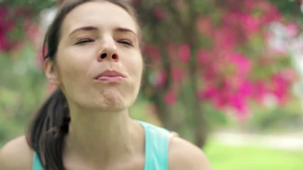 Спортсменка ест яблоко в парке — стоковое видео