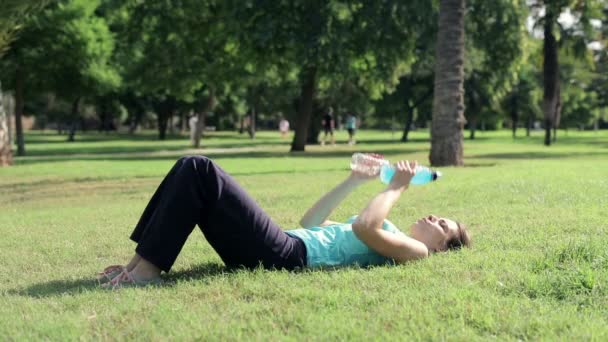 Женщина делает бицепсы упражнения с помощью бутылок — стоковое видео