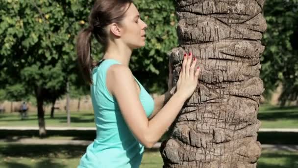 Sportvrouw push-ups doen door boom — Stockvideo