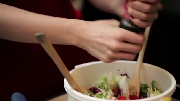 Женщина добавляет специи в приготовленный салат — стоковое видео