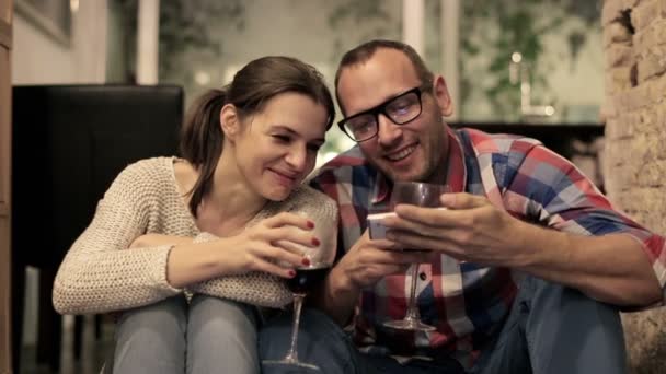 Пара пьет вино и смотрит на смартфон — стоковое видео